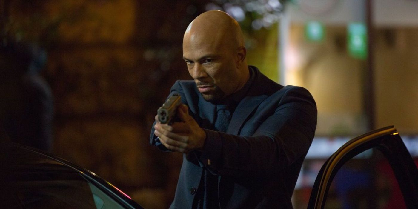 Cassian (Common) muecó y apunta a un arma en John Wick: Capítulo 2.