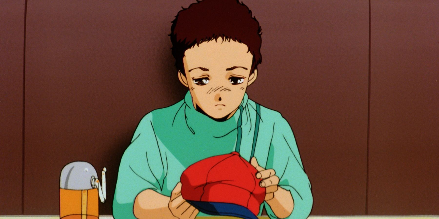 Alfred Izuruha, de Gundam 0080, pareceria triste enquanto segurava um chapéu.