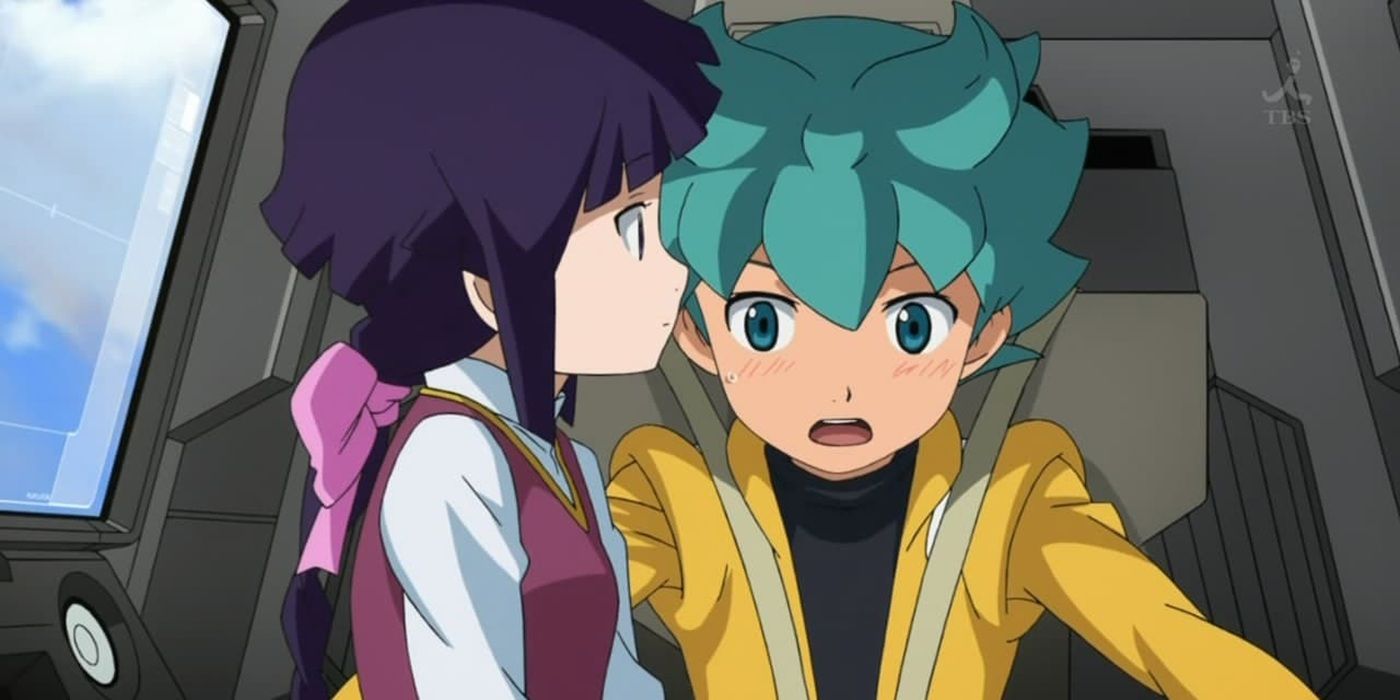 Flit Asuno de Gundam Age pilotando seu Gundam enquanto sua namorada está sentada no colo.