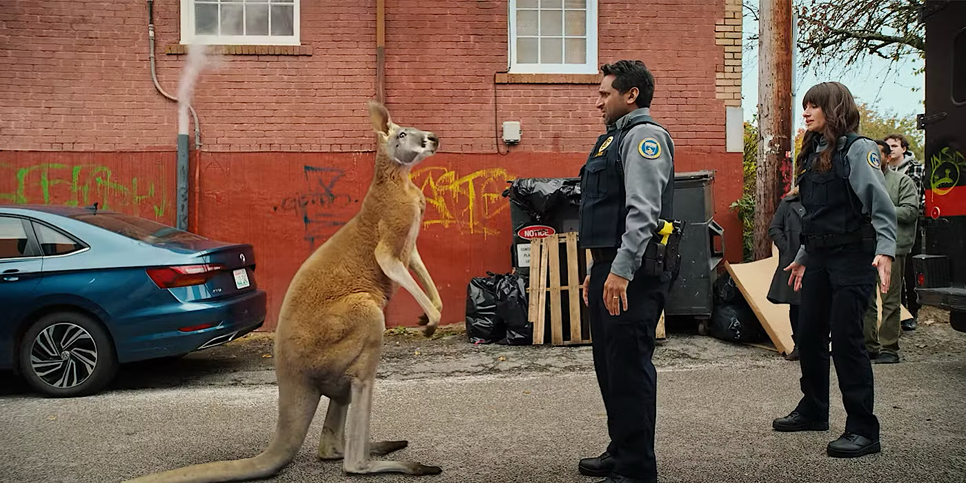 Victoria (Grace Palmer) está detrás de Patel (Ravi Patel) mientras él se enfrenta a un canguro.