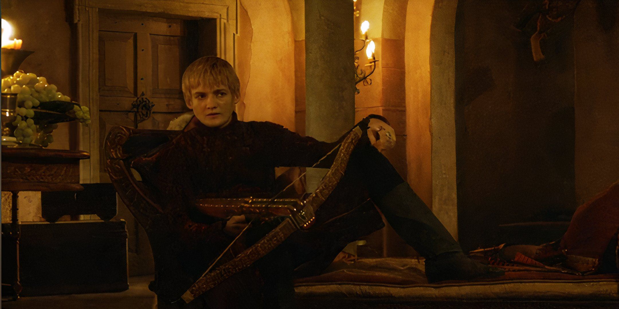 Joffrey holds his crossbow as he looks on from his chair after killing Ros