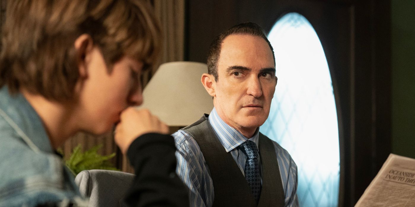 Cliff Wheeler, wearing a three-piece suit, looks across at his son Jason in NCIS: Origins TV show