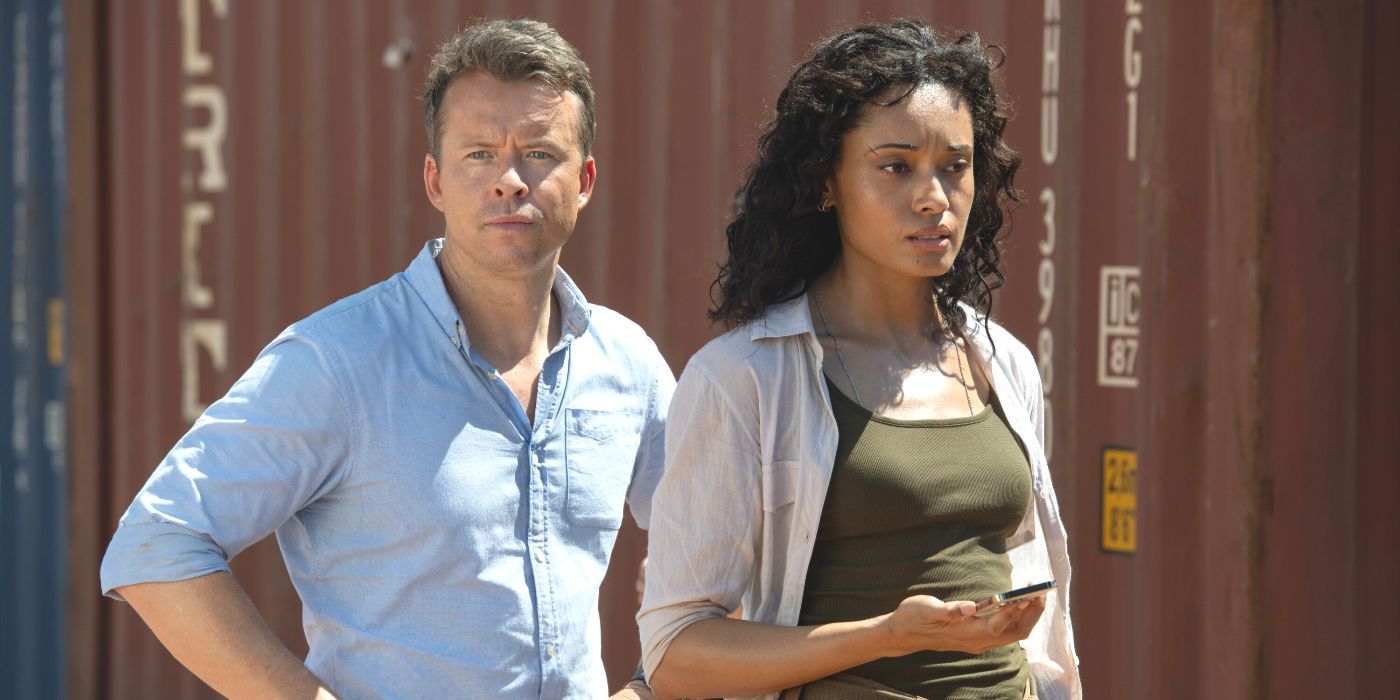 JD in a blue shirt stands next to Mackey in a tan shirt and olive tank top in NCIS: Sydney TV show