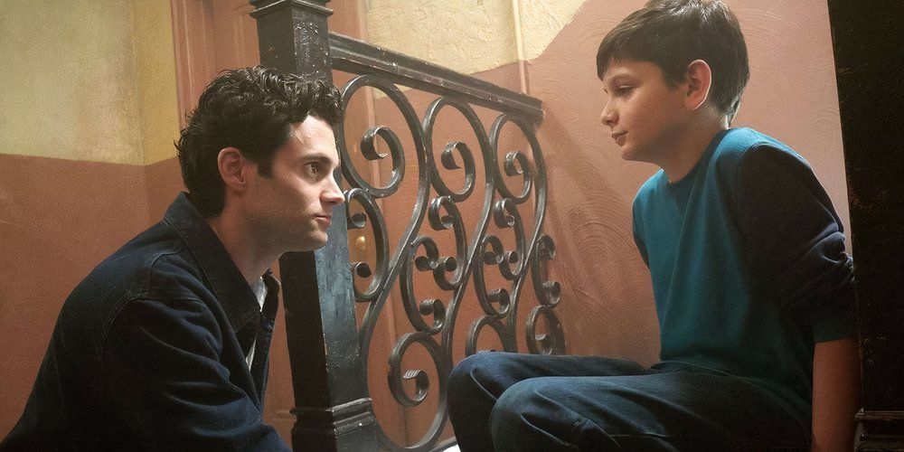 Paco and Joe from You sitting on the stairs talking