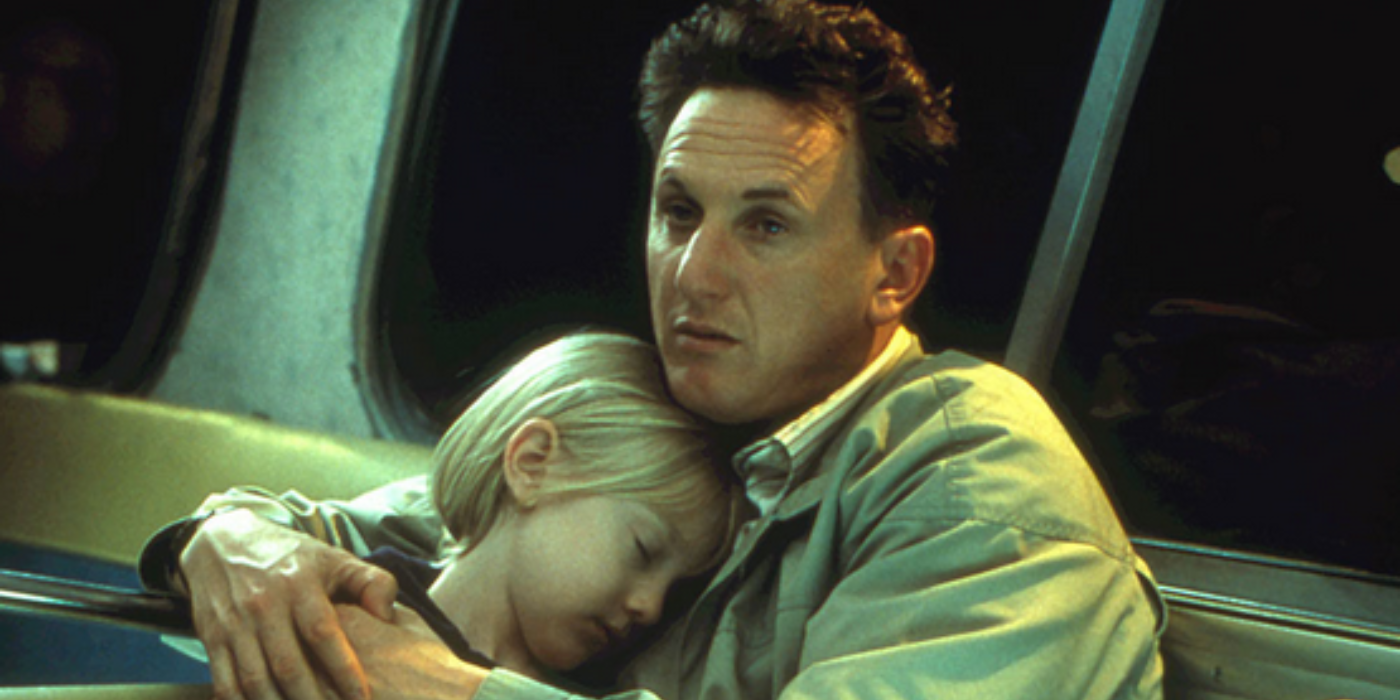 Sam Dawson (Sean Penn) looks upset as he hugs his daughter, Lucy Diamond Dawson (Dakota Fanning), who is sleeping in i am sam.