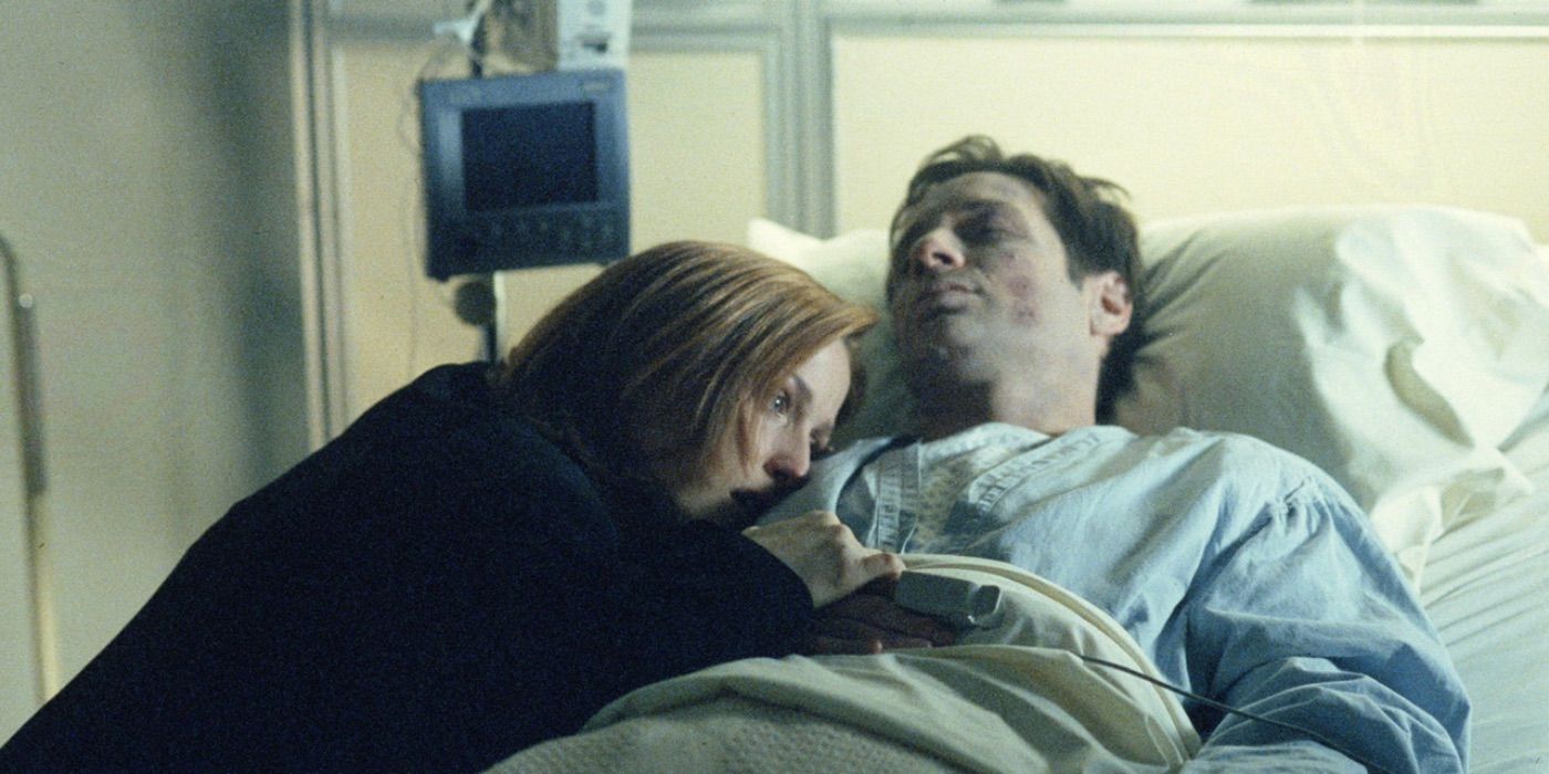 Scully lies next to Mulder in a hospital bed
