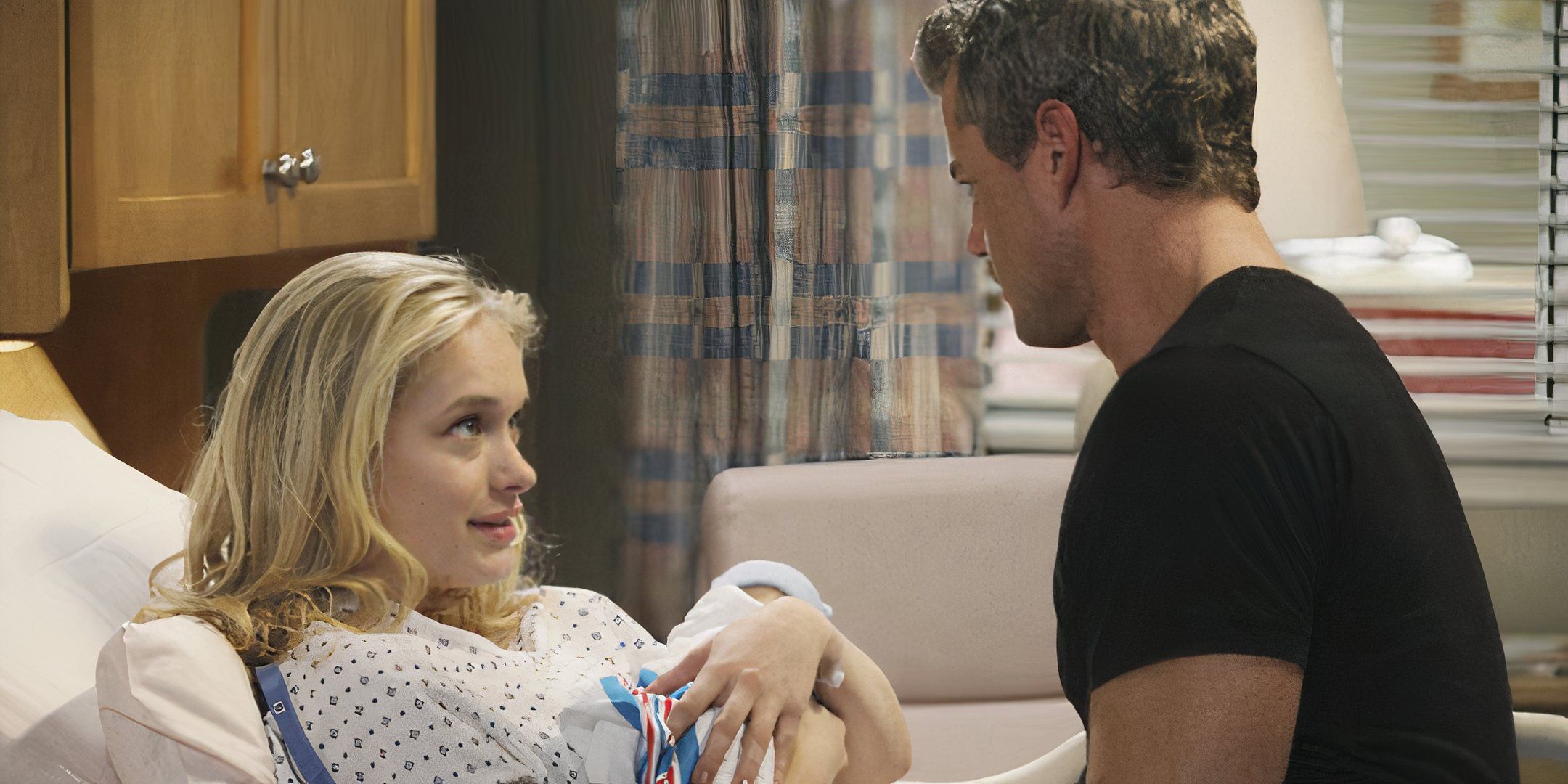 Mark Sloan sitting on Sloan Riley's hospital bed while she holds her baby in Grey's Anatomy