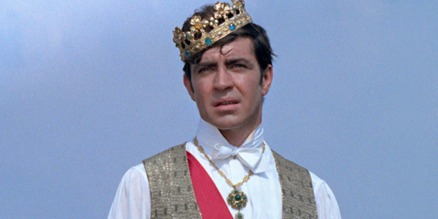 Soldier Charles Plumpick (Alan Bates) is wearing a crown and looks into the distance in The King of Hearts (1966).