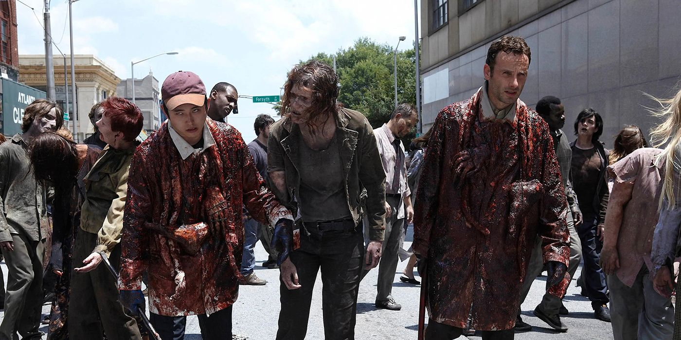 Glenn and Rick walking among walkers, covered in blood in The Walking Dead.