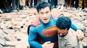 Bearded man helps Superman out of hole in street as he looks up to the sky from Superman 2025