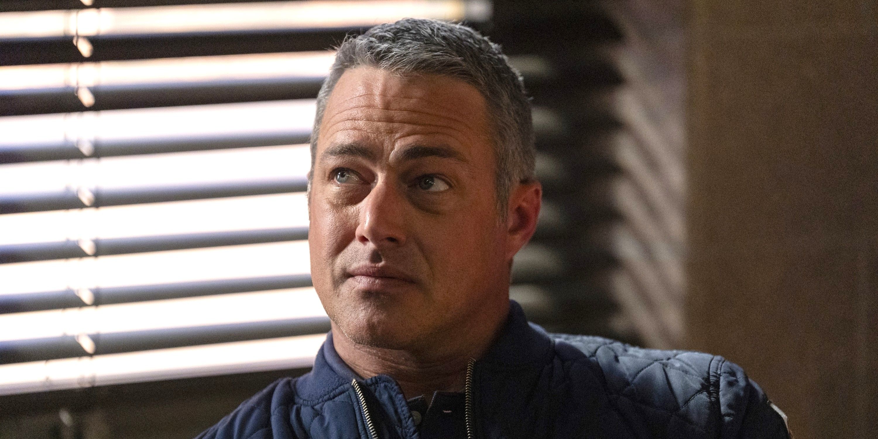 A close-up of Taylor Kinney as Kelly Severide, wearing a blue jacket, on the TV show Chicago Fire