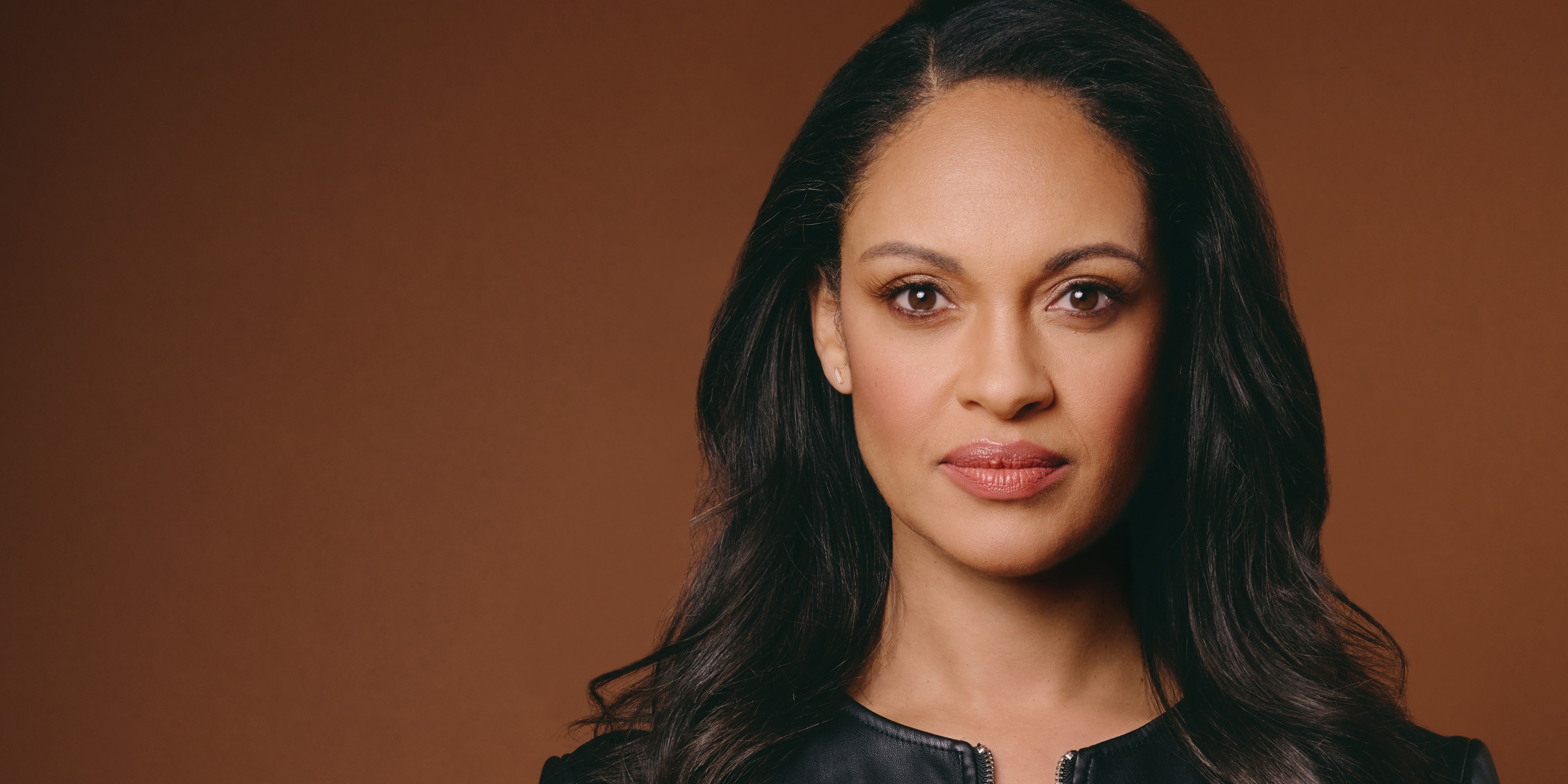 Close-up of actor Cynthia Addai-Robinson carrying a black top on brown background