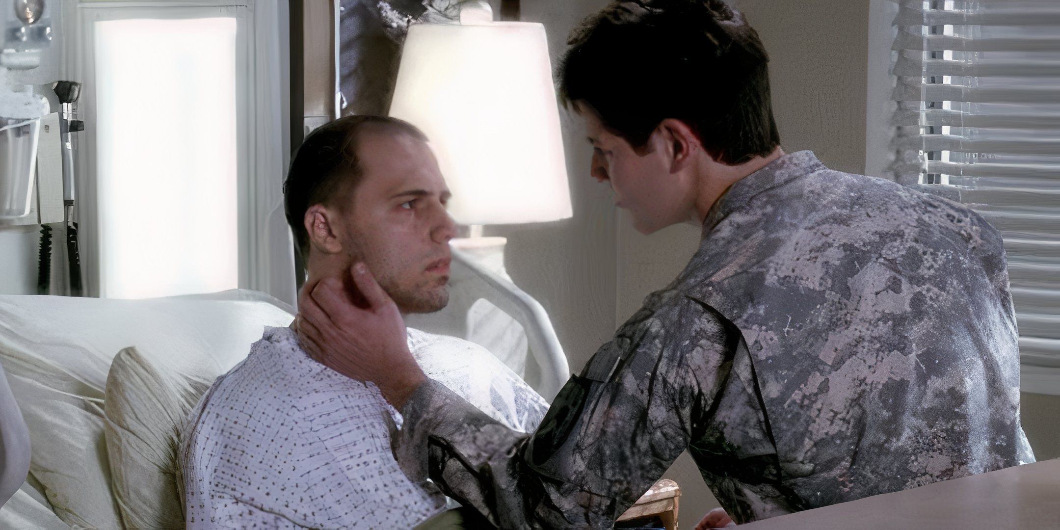 Darren Covington in his hospital bed with Todd caressing his face in Grey's Anatomy