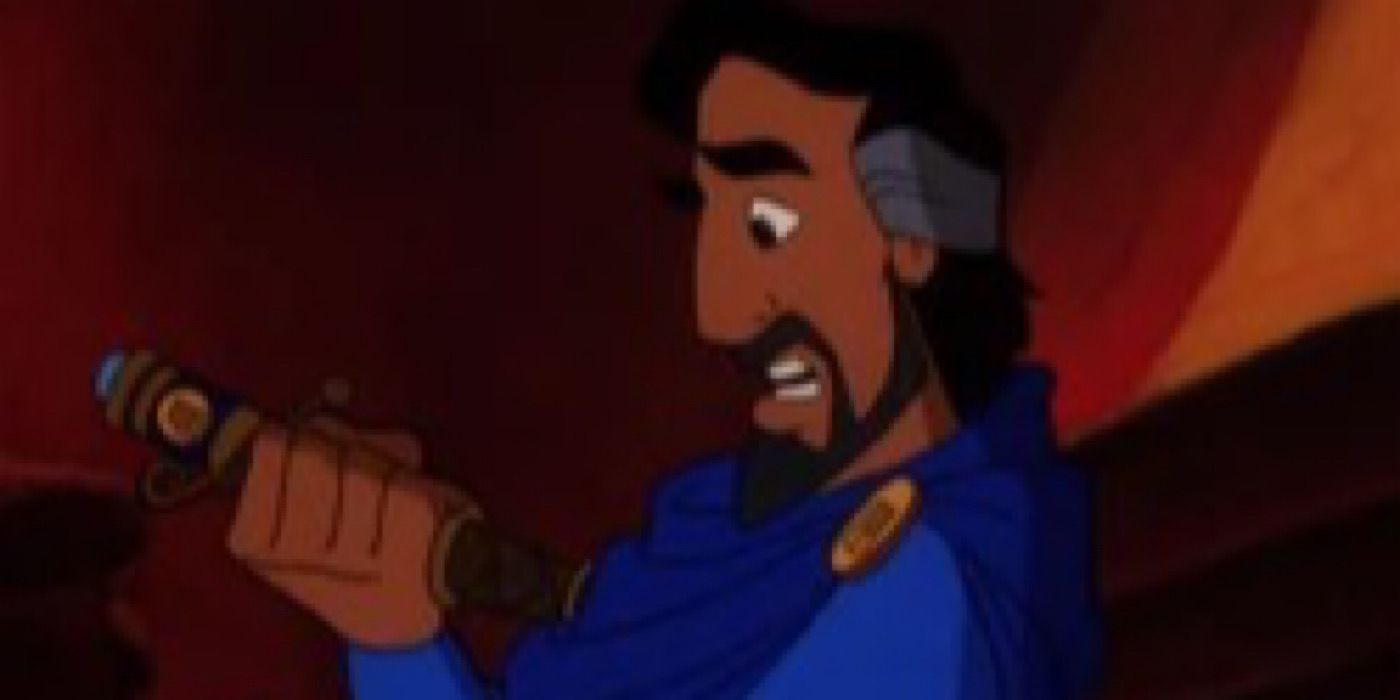 Cassim holds a scroll in one hand and looks at it.