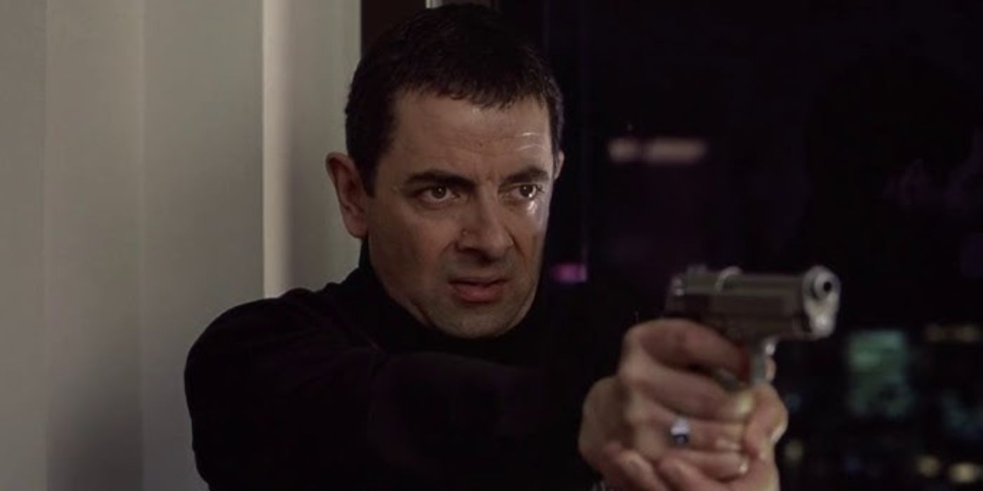 Rowan Atkinson as Johnny English pointing a gun in the movie Johnny English (2003)