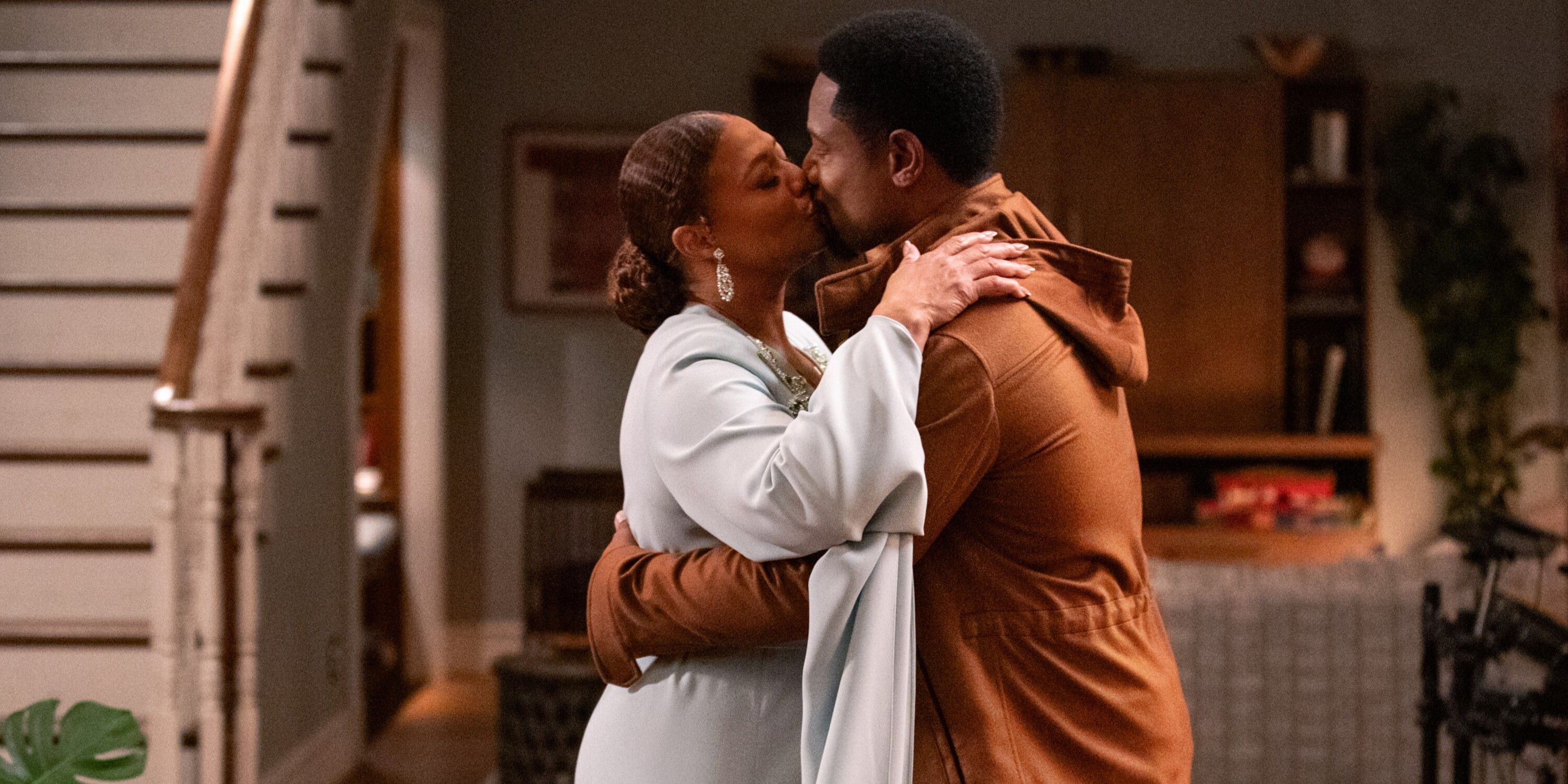 Robyn Mcall, wearing a white dress, kisses Marcus Dante in a brown jacket on The Equalizer TV show