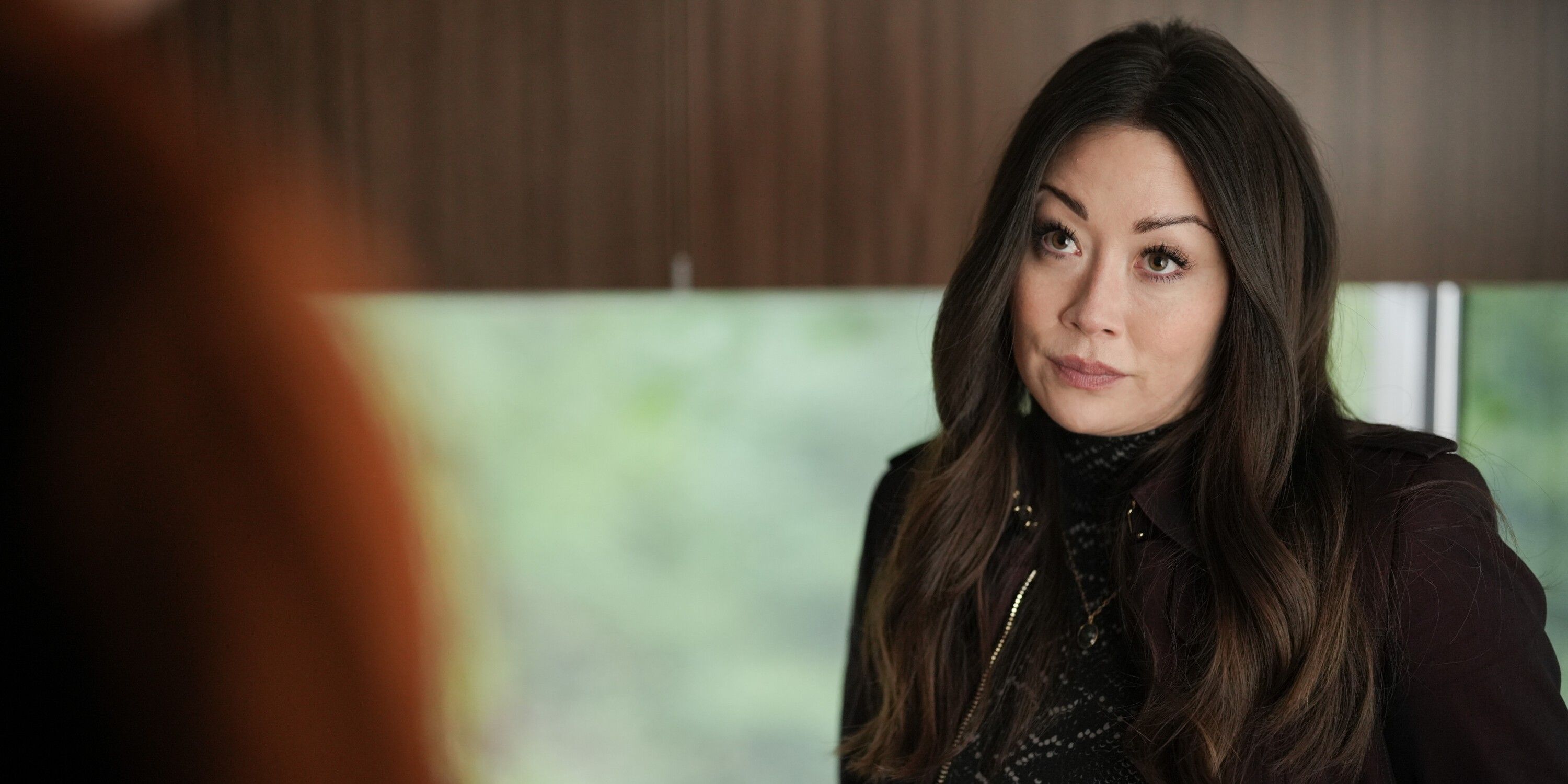 Reenie (Fiona Rene), wearing a black coat and top, standing in Colter's RV in the TV show Tracker
