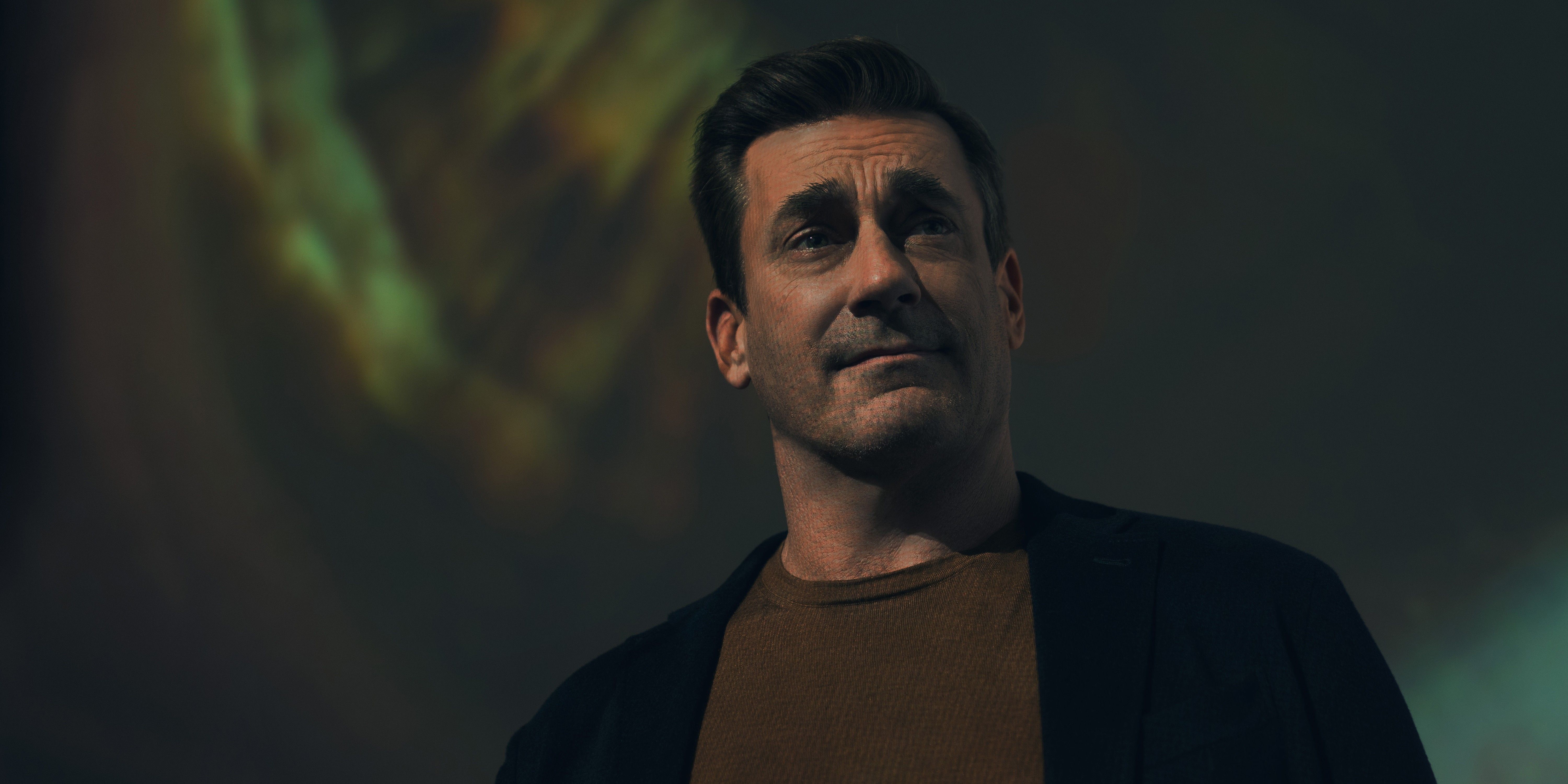 Coop, played by Jon Hamm, wearing a black sweater on a brown shirt in your friends and neighbors