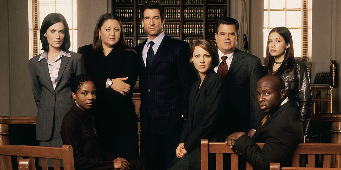 The cast of The Practice stand in an office.