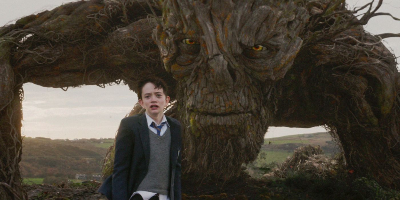 Lewis MacDougall as Conor O'Malley next to the yew tree monster from the movie A Monster Calls (2016)