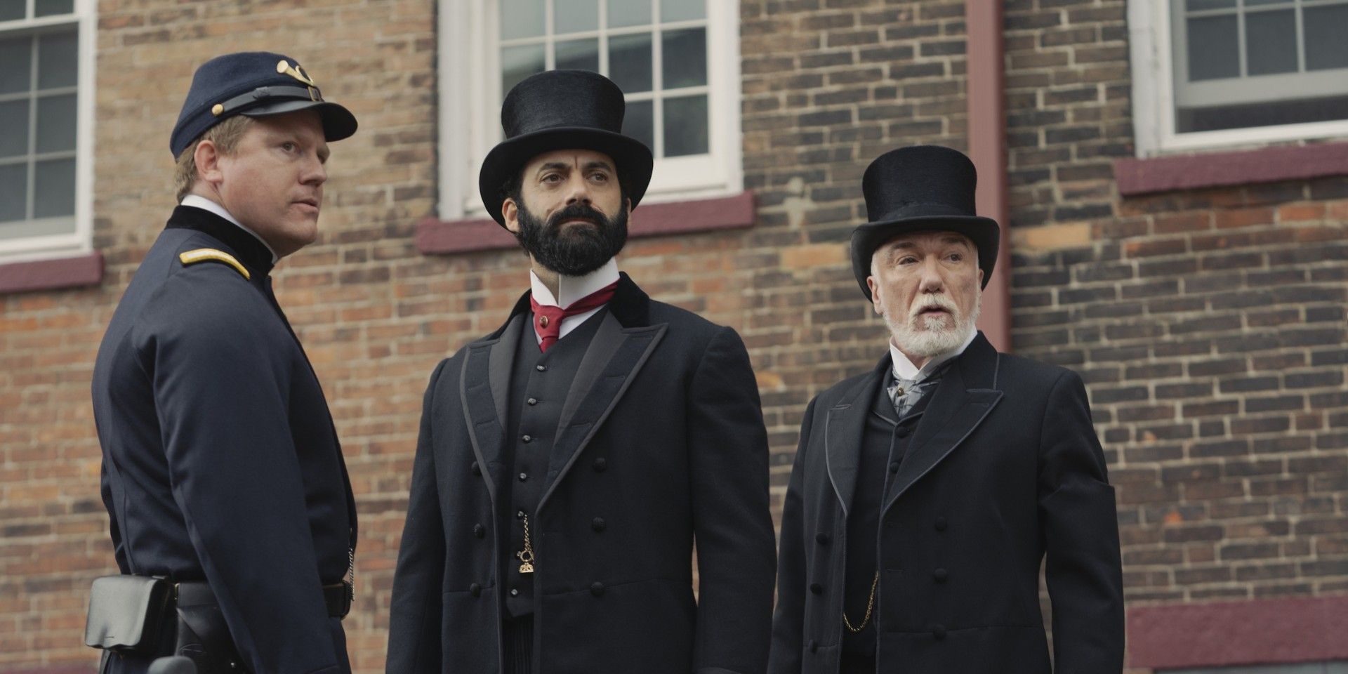A policeman, George Russell and Richard Clay standing together and looking out in The Gilded Age Season 2.