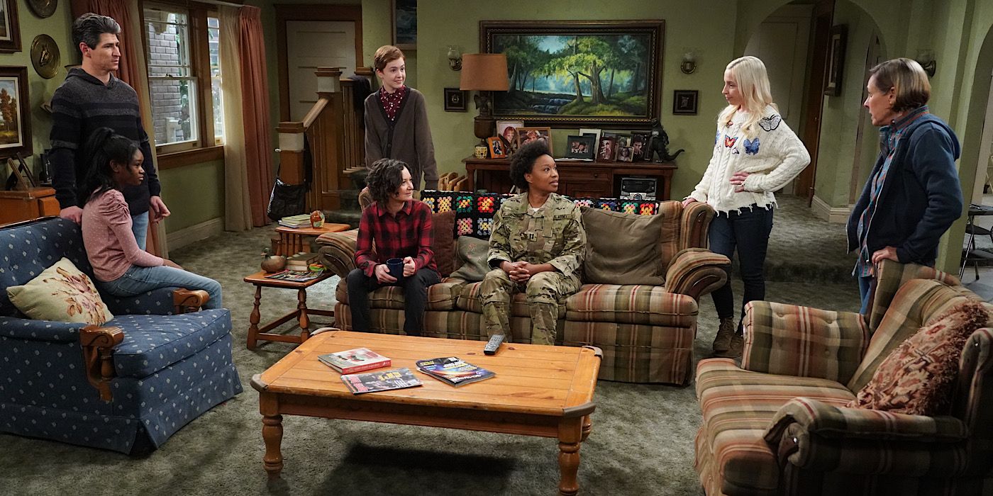 The Conners family surround Geena who is on the couch in her army uniform.