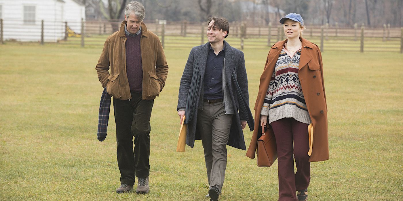 Kendall, Roman, and Shiv are wearing coats and walking across the grass.