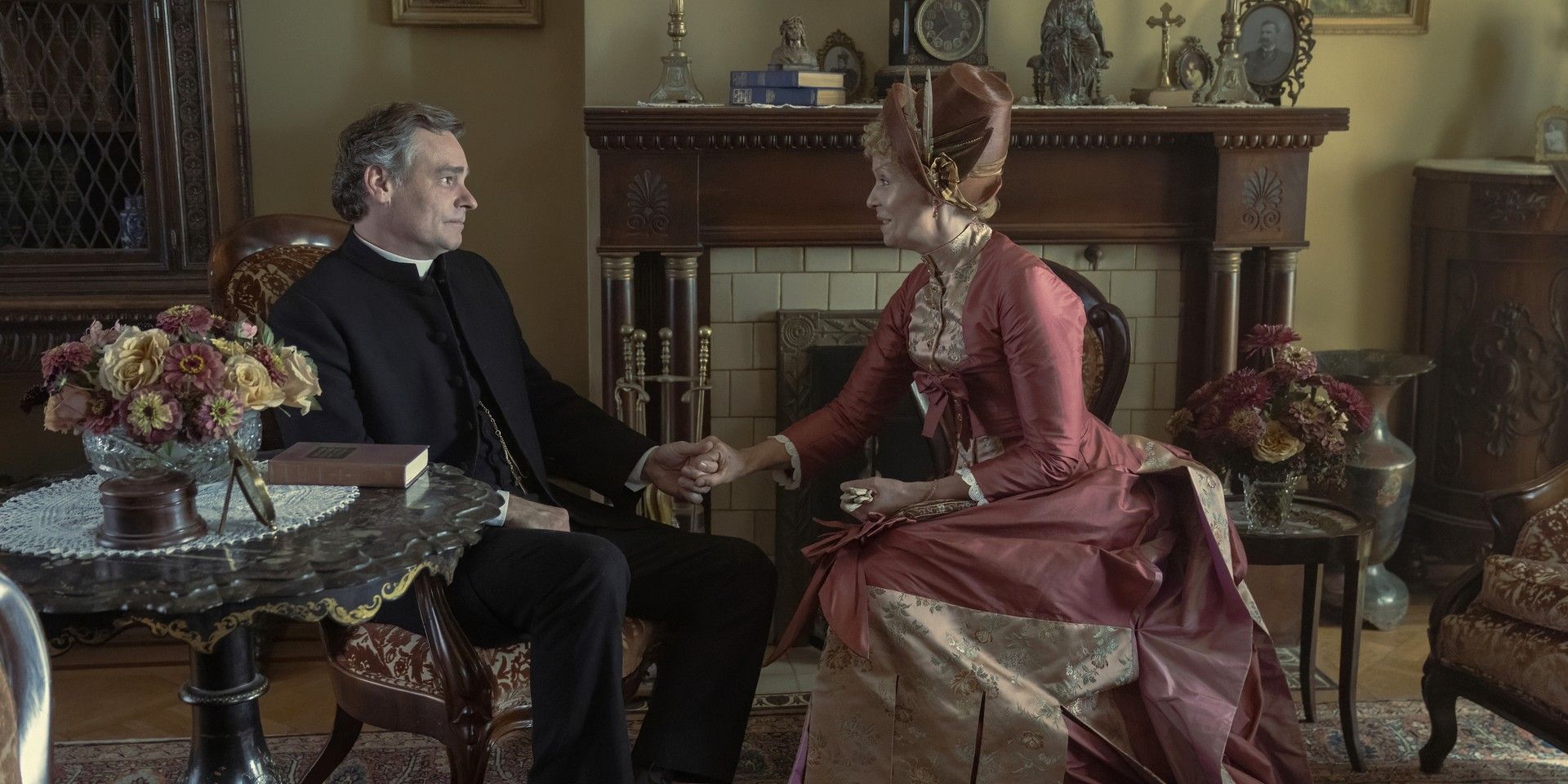 Reverend Luke Forte and Ada Brook sitting and holding hands in The Gilded Age Season 2.