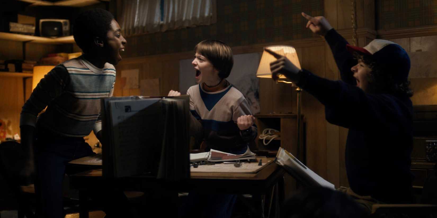 Lucas, Will and Dustin celebrating while playing Dungeons & Dragons on Stranger Things
