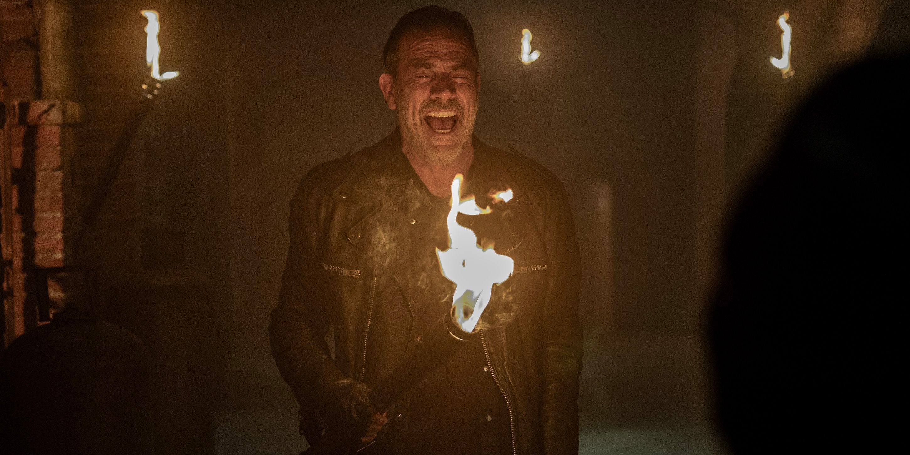 Negan (Jeffrey Dean Morgan) laughing and holding a torch on The Walking Dead: Dead City