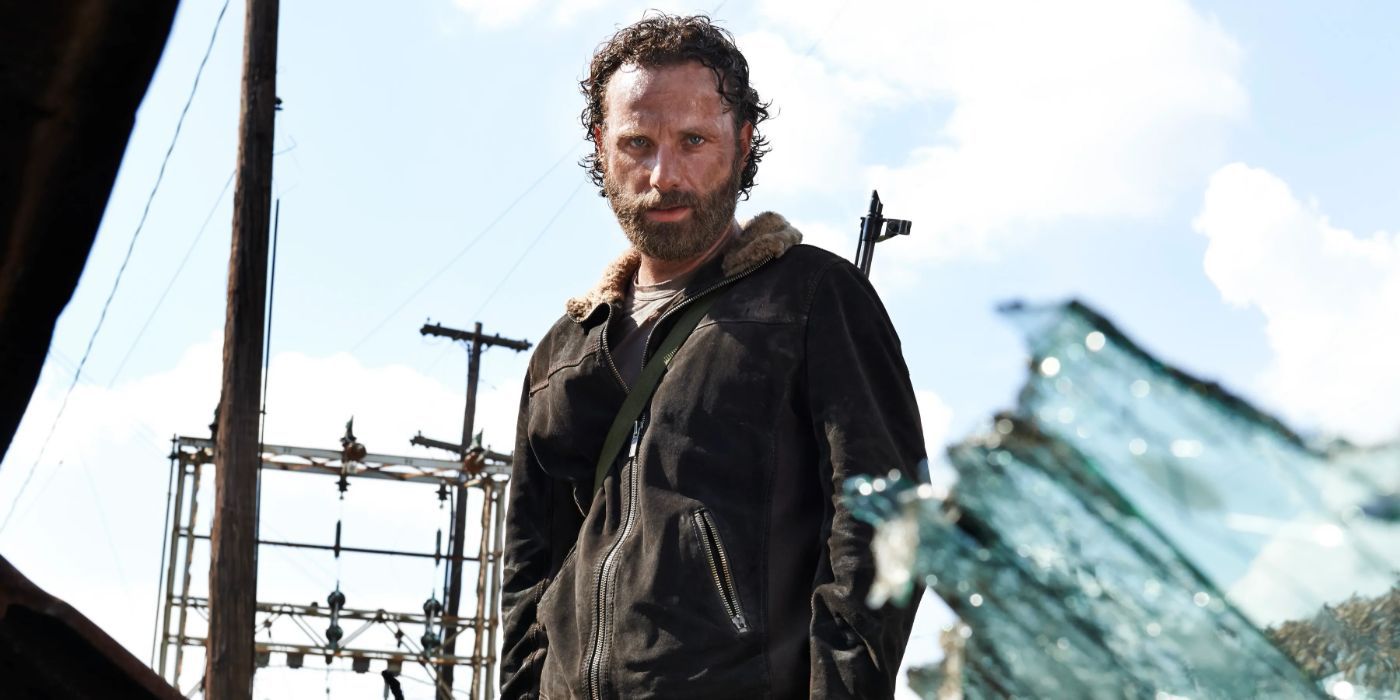 Andrew Lincoln as Rick Grimes looking at a destroyed car from the TV series The Walking Dead