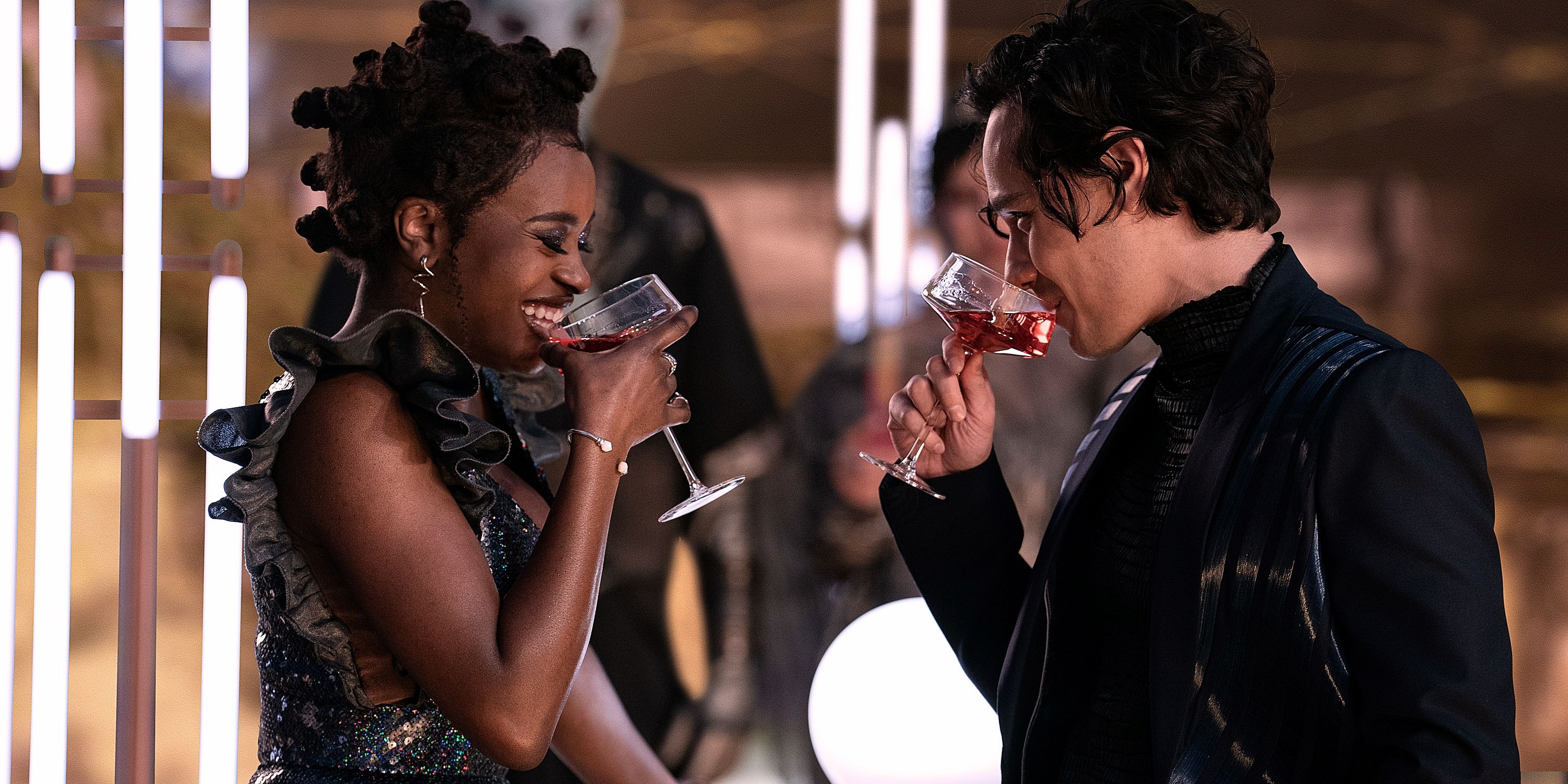 Uhura in an evening dress and a man in a dark suit drinking in profile Star Trek Strange New Worlds