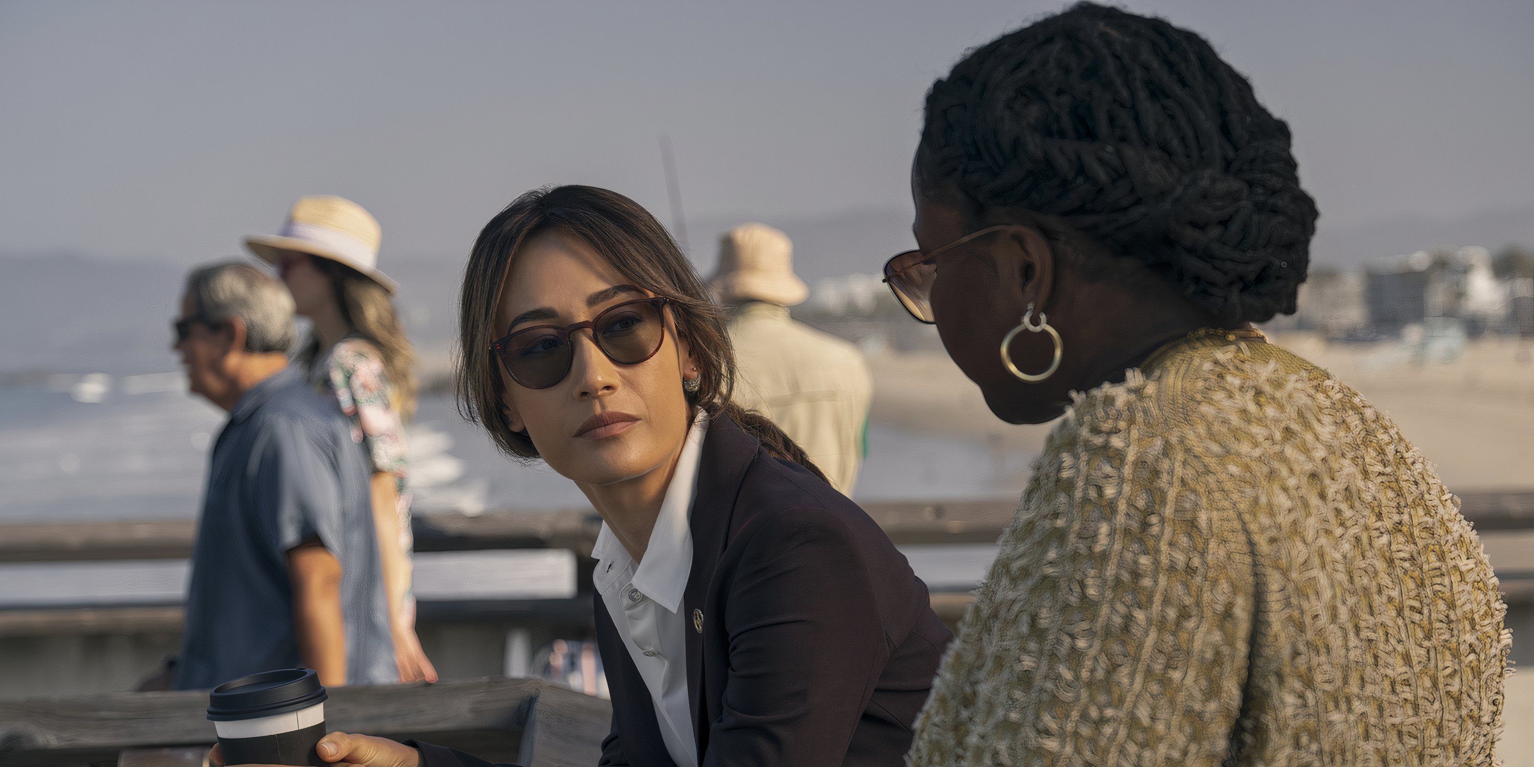 Renee Ballard, wearing a black suit and sunglasses, is next to Samira Parker in the Ballard TV show