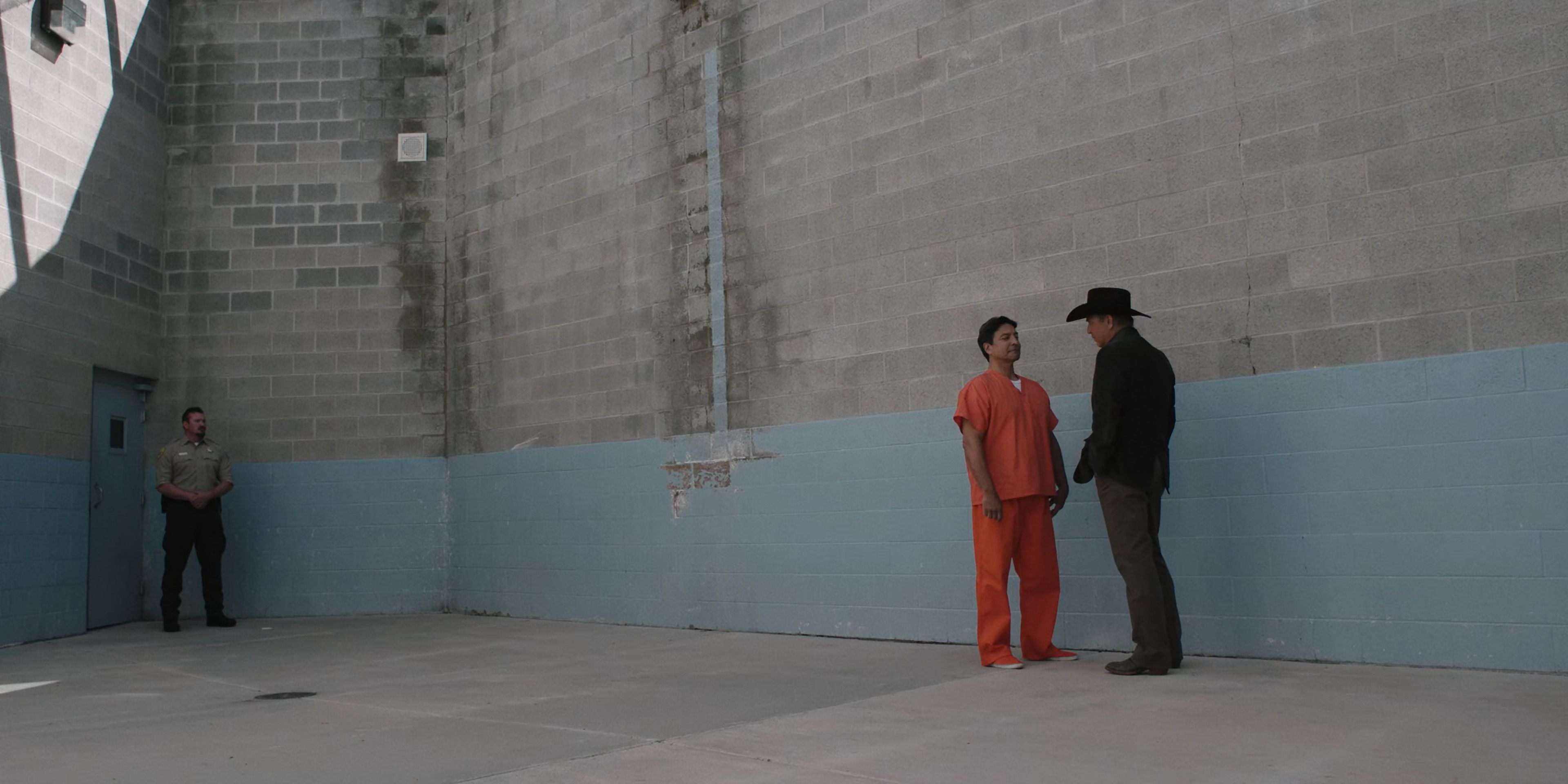 Chief Thomas Rainwater and John Dutton stand in a holding space in Yellowstone Season 1