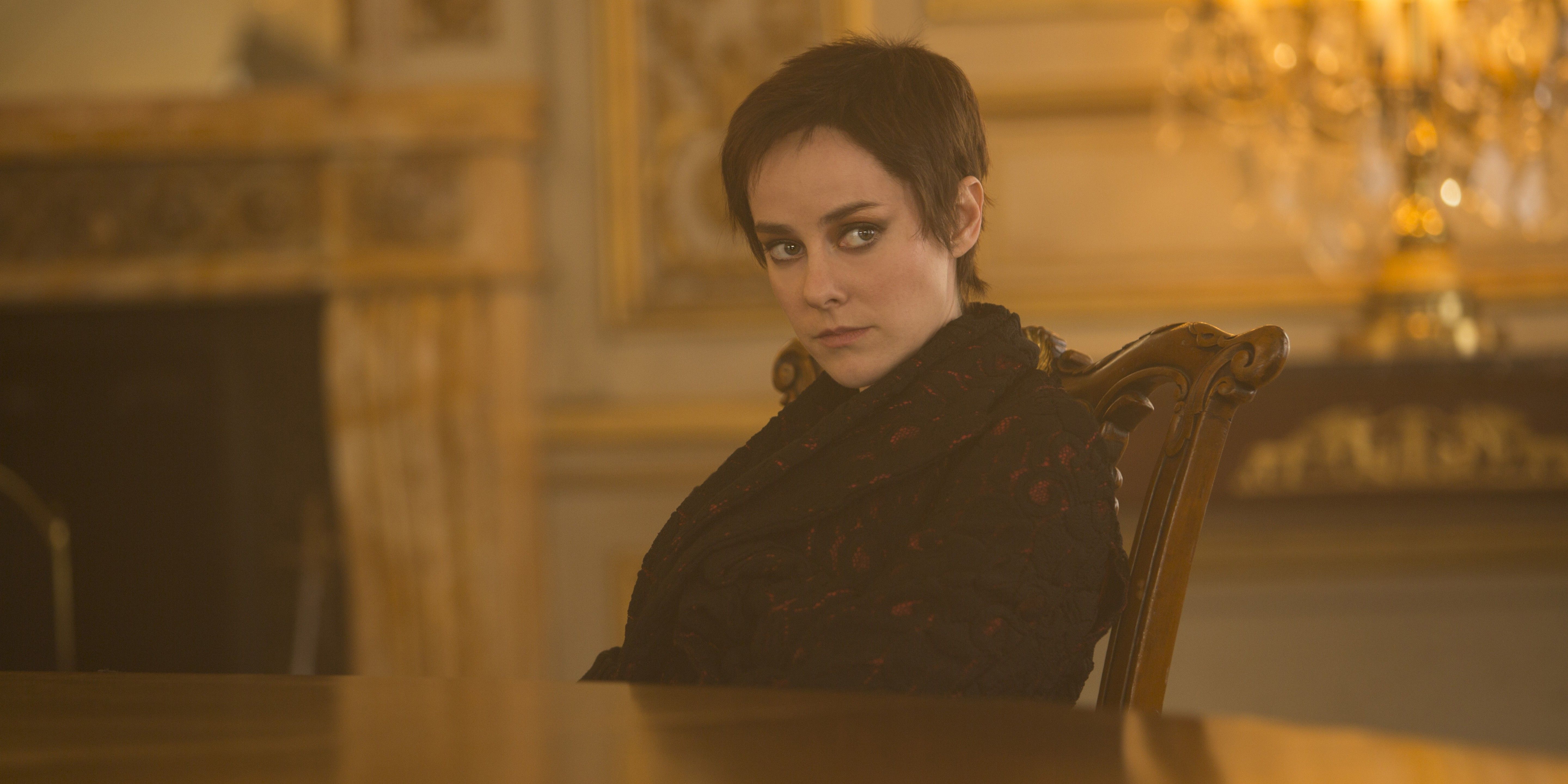 Johanna Mason (Jena Malone) sitting at a table in the Snow manor in the Hunger Games: Mockingjay - Part 2.