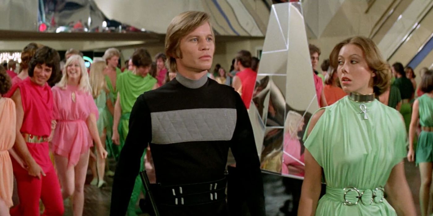 Michael York como Logan 5 y Jenny Agutter como Jessica 6 caminando en una multitud de la película Logan's Run (1976)