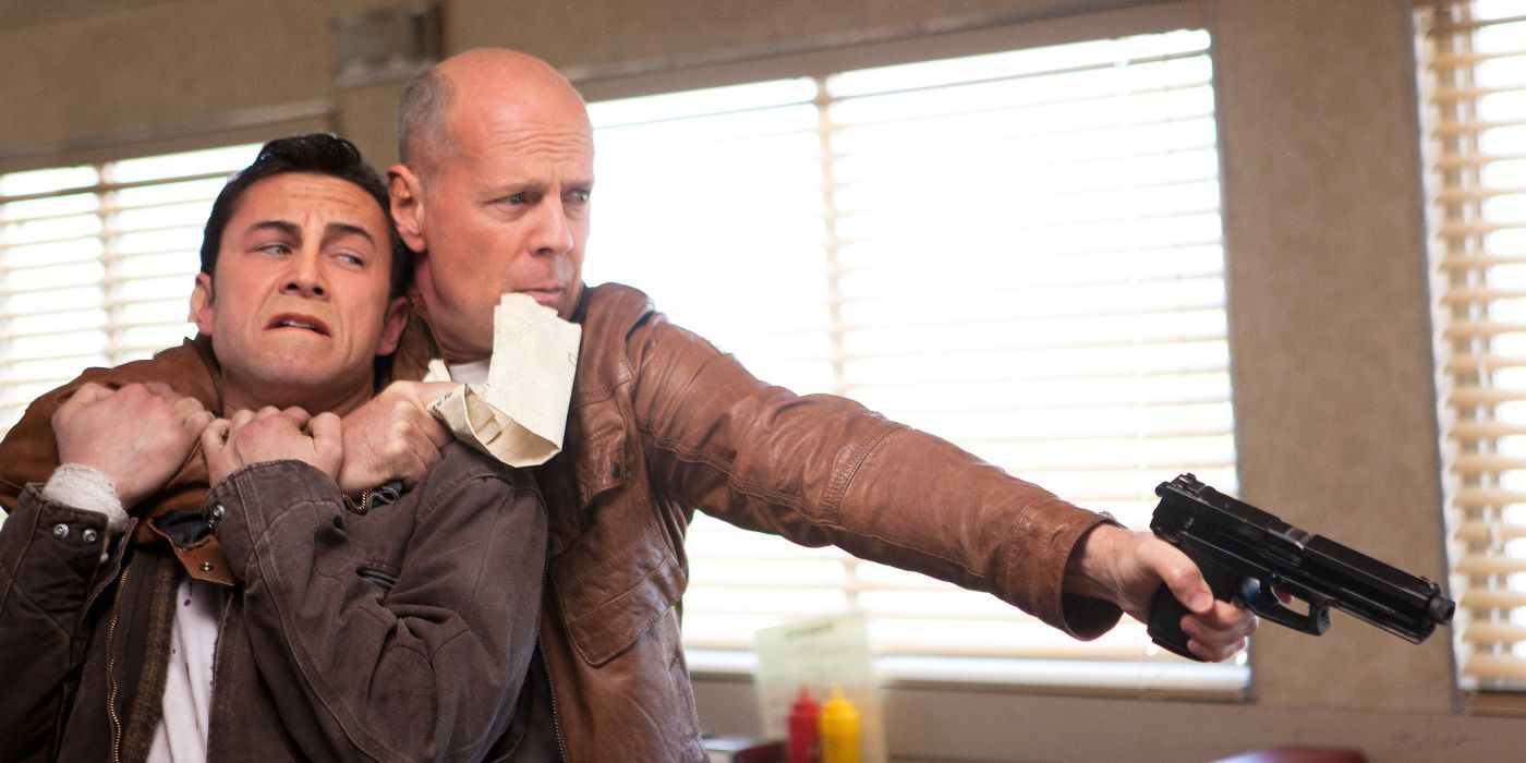 Joseph Gordon-Levitt en el papel de Joe y Bruce Willis como el viejo Joe apuntando a una pistola de la película Looper (2012)