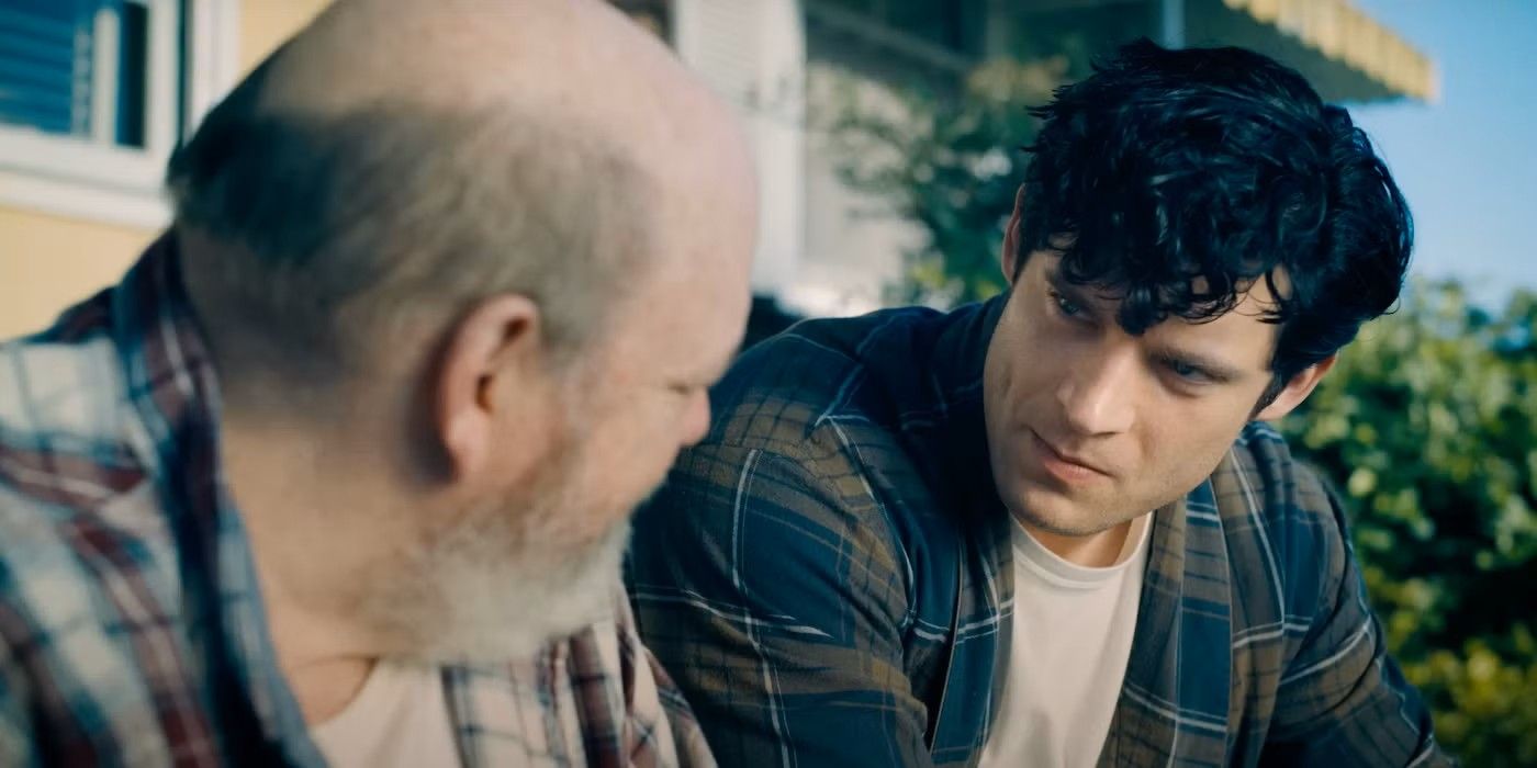 Clark Kent, vestindo uma camisa xadrez escura, observando Jonathan Kent no filme Superman de 2025