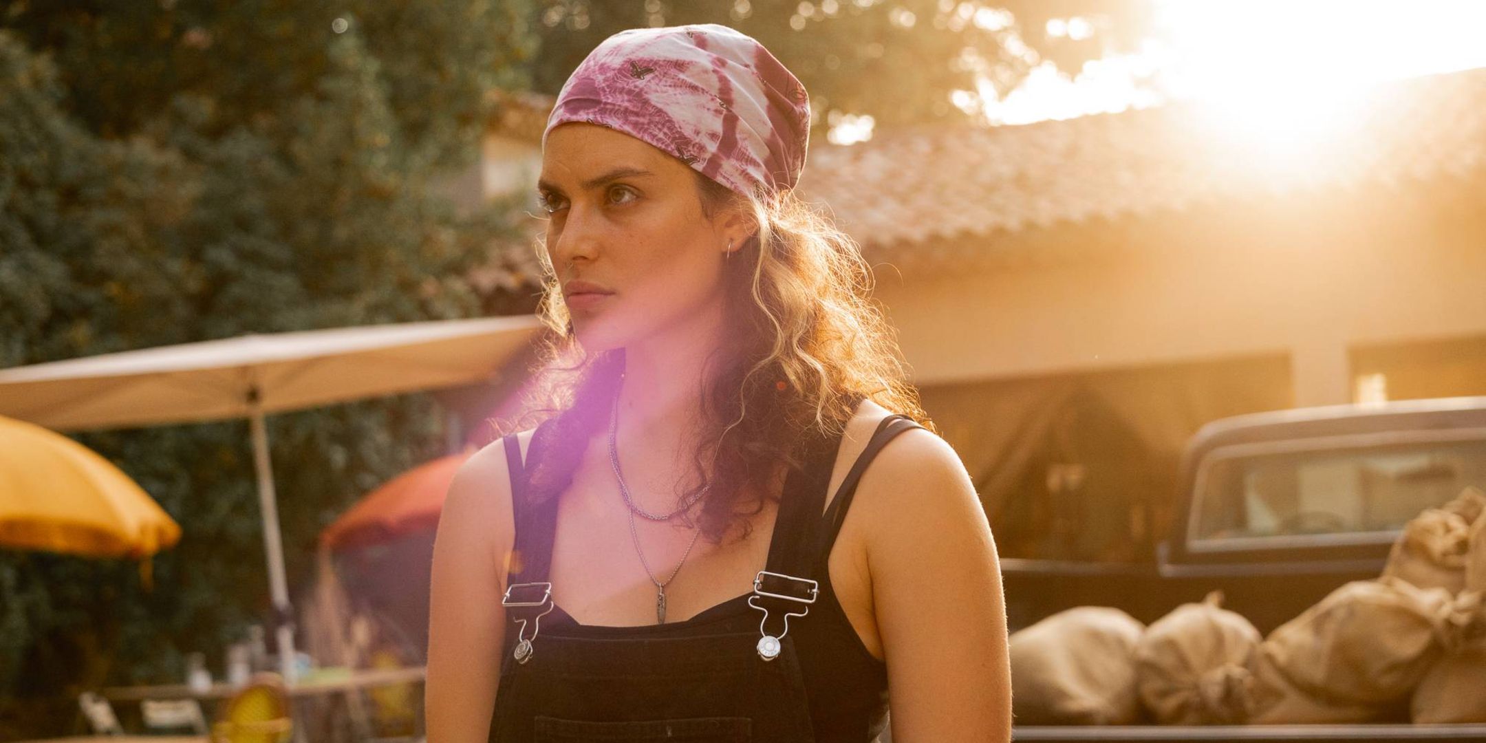 A woman stands bathed in sunlight in Under a Dark Sun