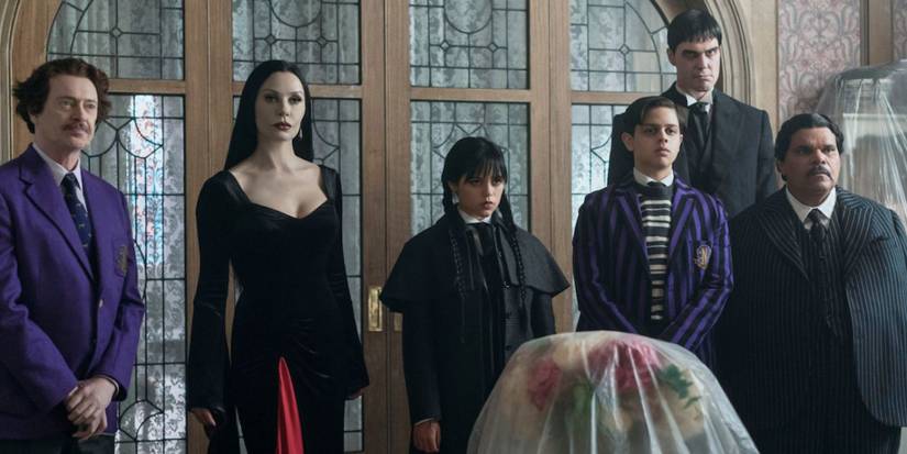 Principal Dort and the Addams Family members standing together in Wednesday Season 2.