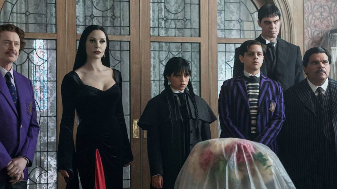 Principal Dort and the Addams Family members standing together in Wednesday Season 2.