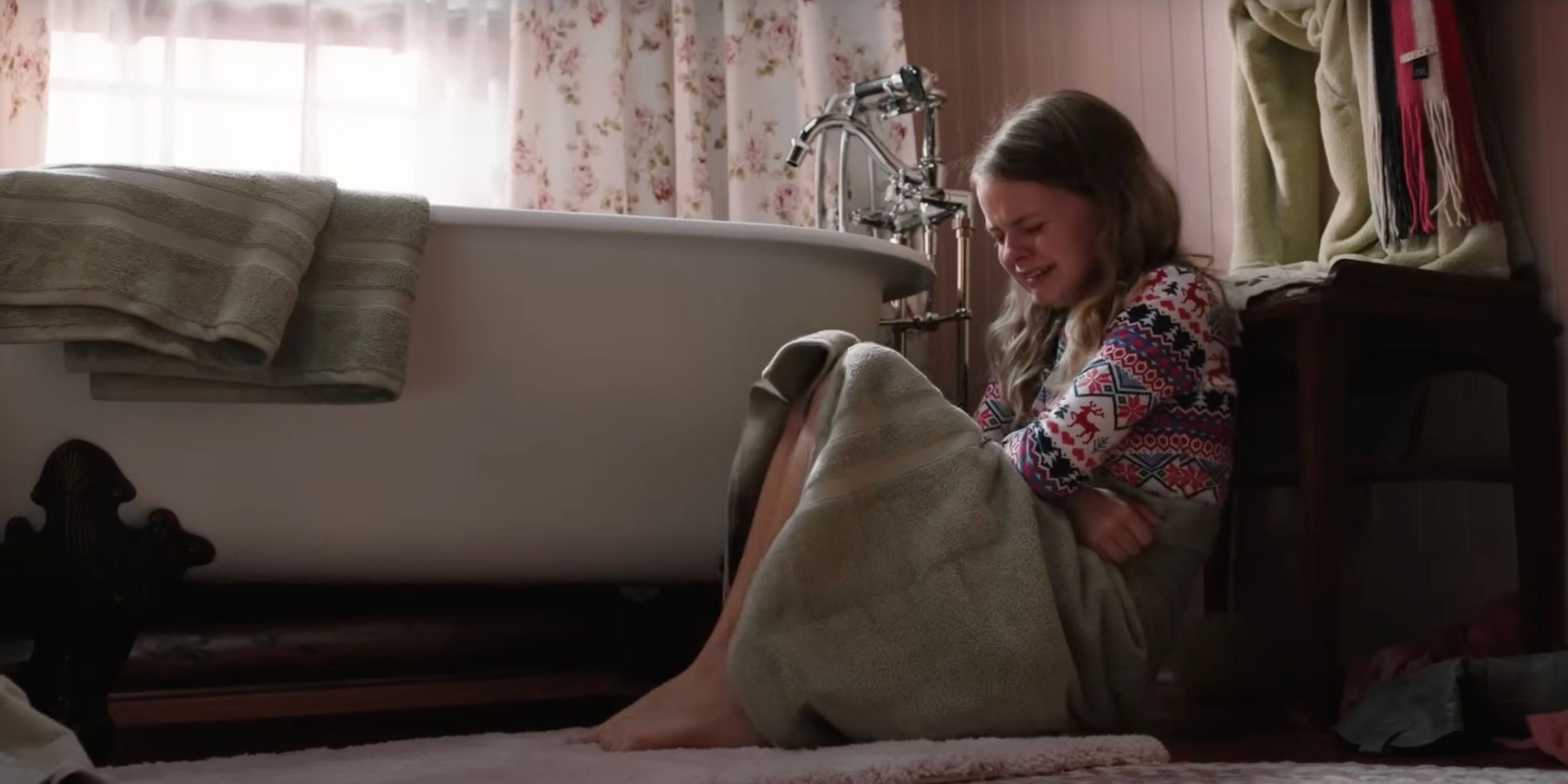 A young Beth Dutton crying on the bathroom floor on Yellowstone