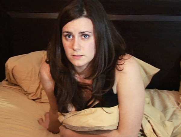Katie sits in bed talking to her husband in Paranormal Activity (2007)