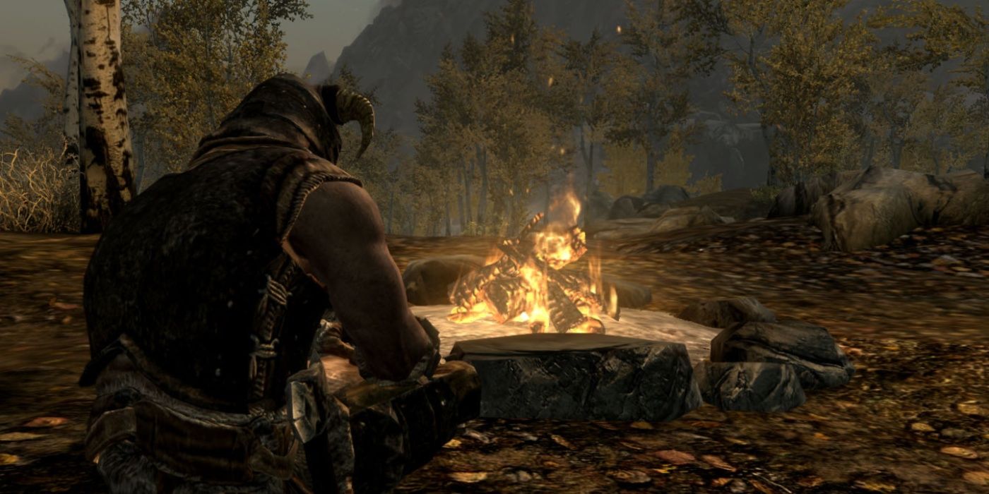 The dragonborn in Skyrim is sitting near a campfire.