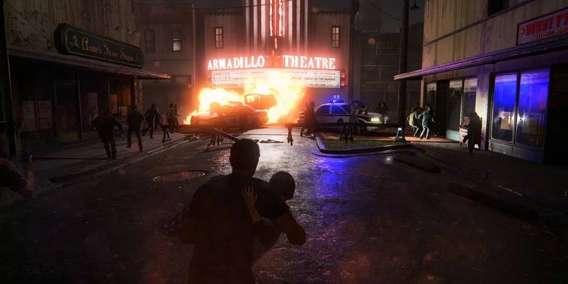Joel holding Sarah while a car explodes in front of them