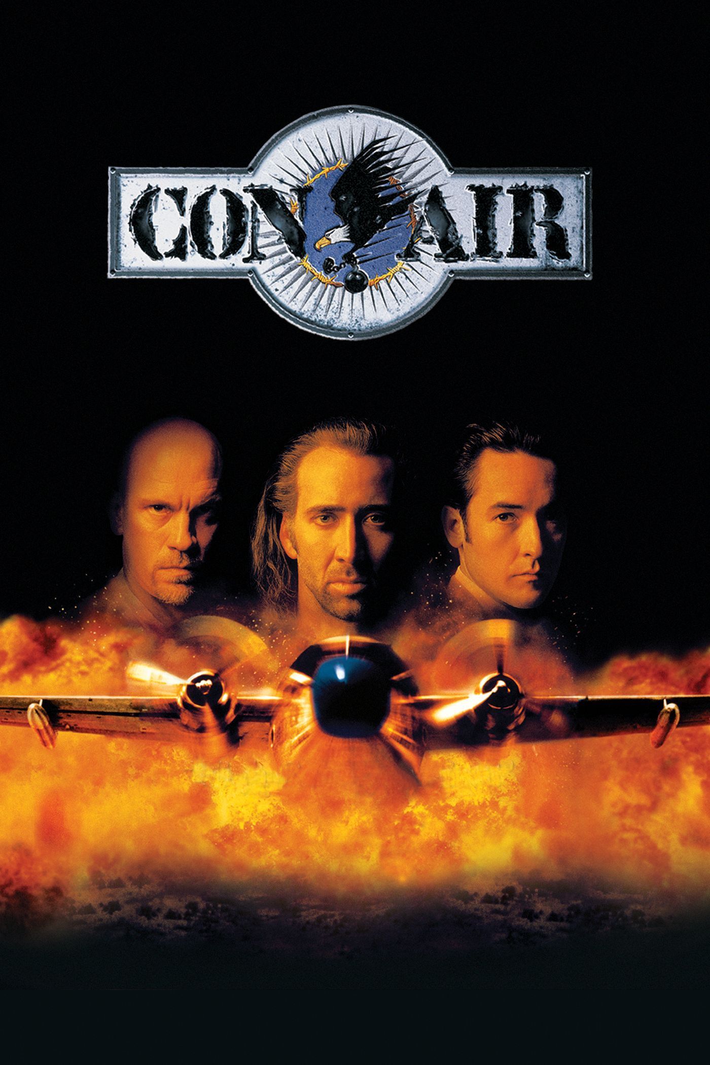 The Con Air poster depicts the faces of Cameron Poe (Nicolas Cage), Cyrus the Virus (John Malkovich) and U.S. Marshall Vince Larkin (John Cusack) above a plane dlying through flames.